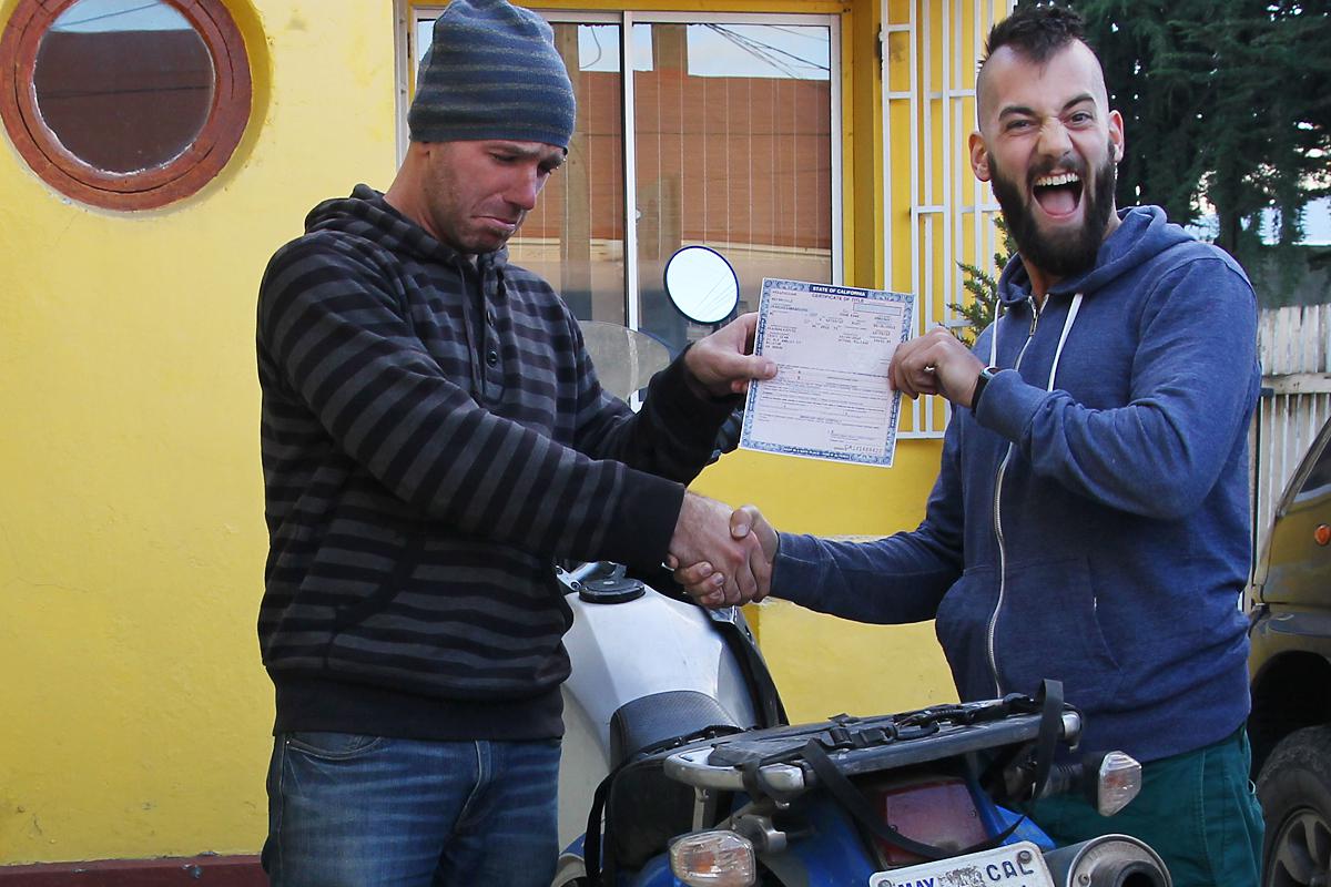21,219 - Punta Arenas -- Sean hands over the motorcycle title to Leo, its new owner, to start a trip back north.